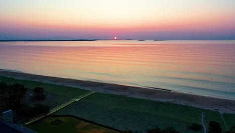 Vista-Aérea-Por-Drones-Del-Hermoso-Amanecer-En-La-Playa-En-Saco-Maine-Con-Colores-Reflejados-En-Las-Olas-Del-Océano-Y-Casas-De-Vacaciones-A-Lo-Largo-De-La-Costa-Atlántica-De-Nueva-Inglaterra