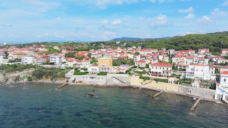 Vista aerea di acque limpide e turchesi e di immobili costieri di lusso nella parte meridionale di Livorno, Italia.