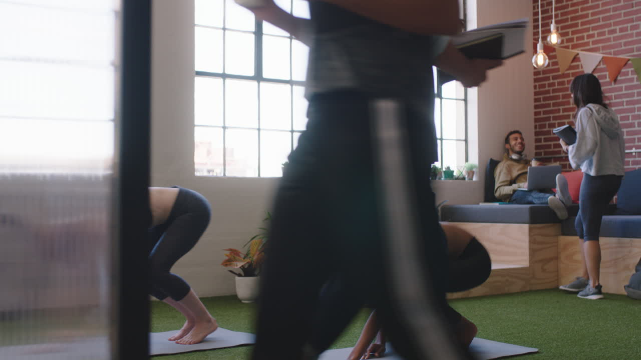 젊은 다민족 비즈니스 학생들이 함께 일하고 팀 리더 비즈니스맨이 아이디어를 공유하고 동료들이 요가를 하고 현대적인 사무실 작업장에서 휴식을 취하고 있습니다.