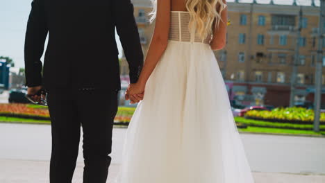 just married woman and man join hands standing on street