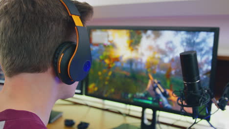 hombre jugando en casa sentado en el escritorio con auriculares para transmisión en vivo
