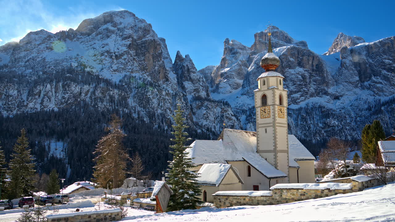 View of the Parrocchia di Colfosco in the Colfosco mountain village covered in snow, in South Tyrol, Dolomites, Northern Italy