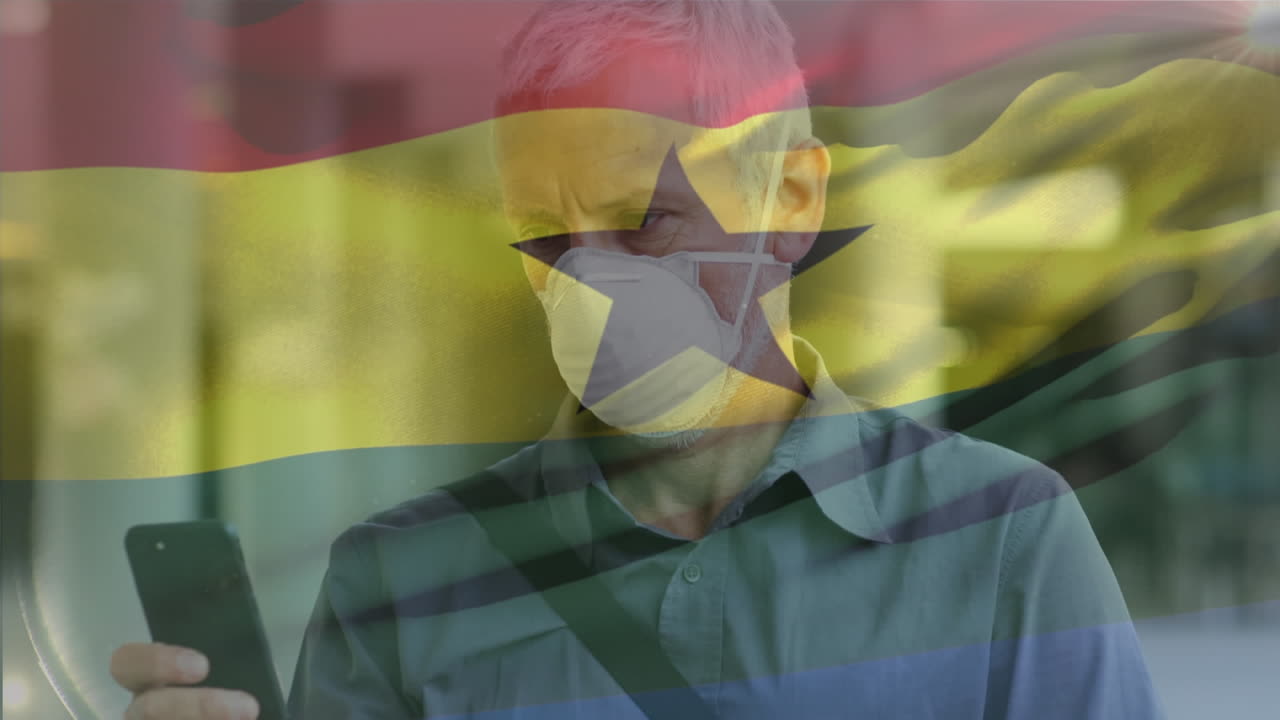 Animazione di bandiera del Ghana che sventola su sfondo di uomo caucasico con mascherina che usa lo smartphone per strada