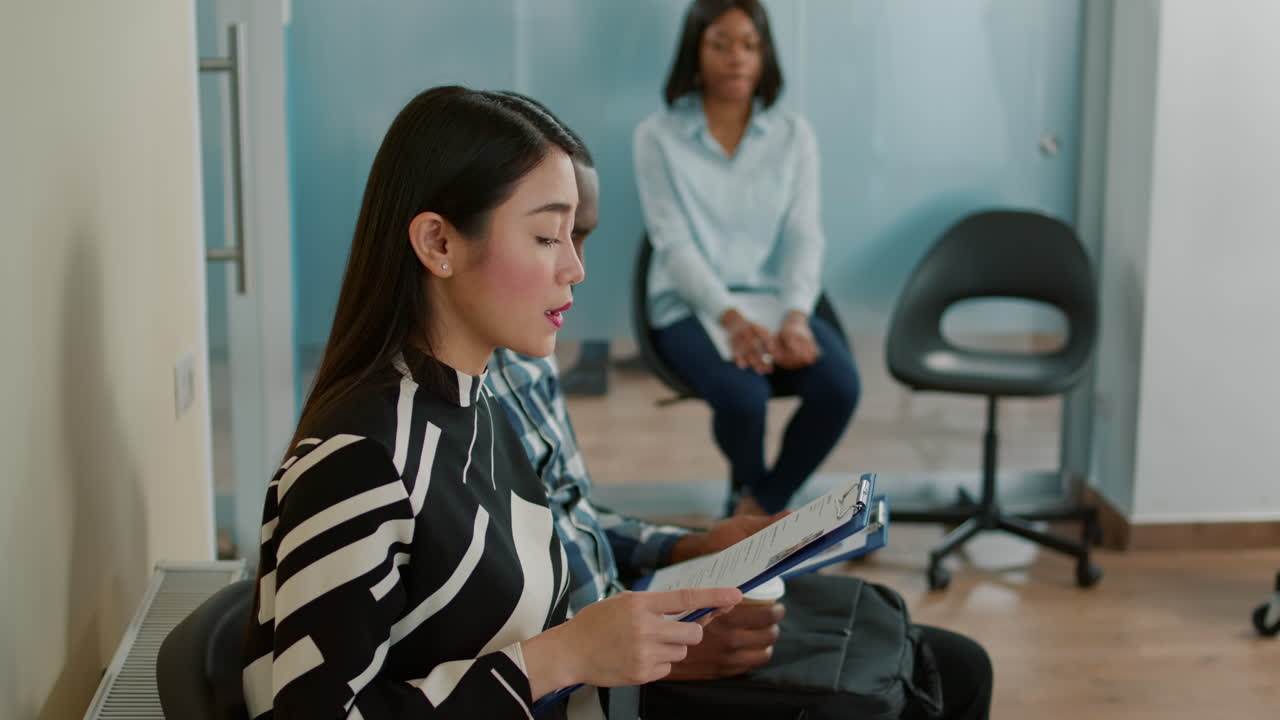 Applicant reading selection information on paper and waiting in lobby
