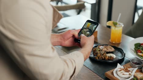 Close-up-of-male-hands-with-smartphone-taking-pictures-of-dishes-on-table