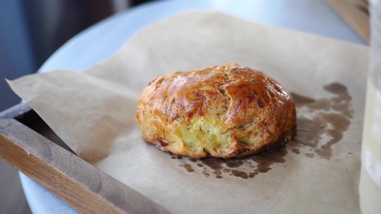 Mano che prende uno squisito scone appena sfornato dalla carta da forno