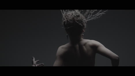 a woman dressed as mother nature moves slowly in a dance-like motion