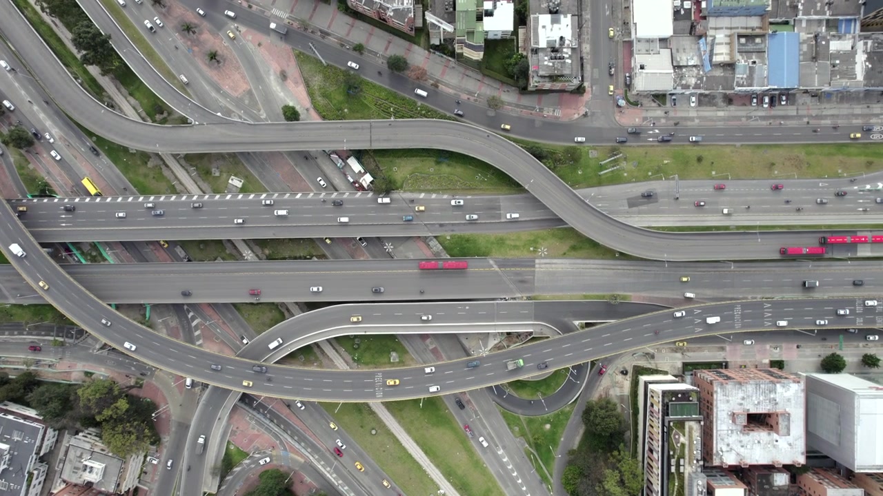 High-altitude drone view panning across a major highway interchange in Bogotá, Colombia.