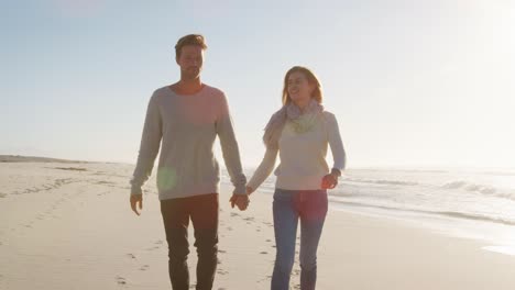 loving couple walking along winter beach together