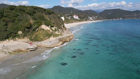 Aerial-drone-shot-over-famous-Torii-gate-at-Izu-Shirahama-Beach