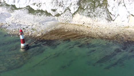 disfruta de una serena y lenta panorámica del icónico faro beachy head en la costa sur de sussex, capturado en un día caluroso y soleado.