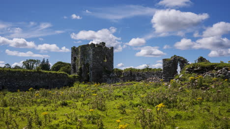 Time-lapse-of-abandoned-castle-ruins-in-rural-grass-landscape-of-Ireland-on-a-sunny-summer-day