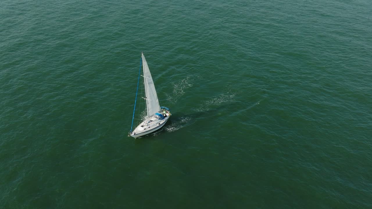 vista aérea estableciendo de un velero blanco en el mar báltico tranquilo, yate de vela blanco en medio del mar sin límites, día soleado de verano, tiro abierto moviéndose hacia atrás, inclinarse hacia arriba