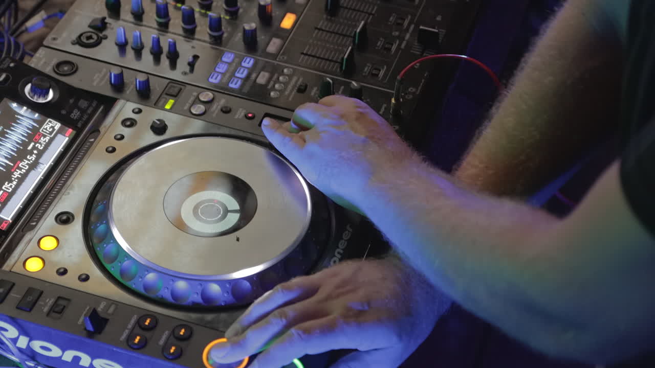 DJ standing near the mixer at a nightclub and pressing buttons