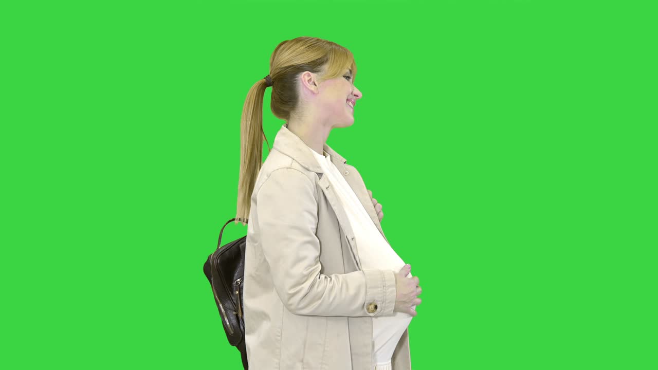 Happy healthy pregnancy Pregnant young blonde Caucasian woman walking on a Green Screen, Chroma Key
