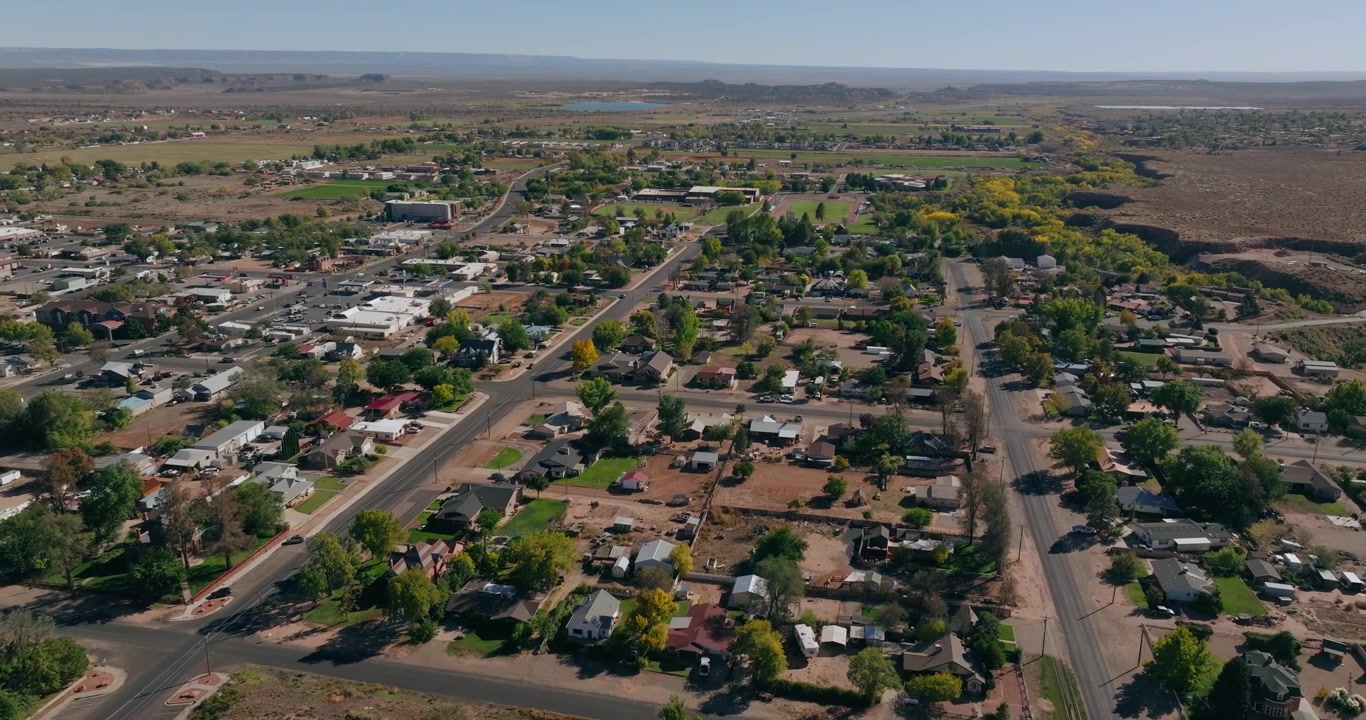 Aerial establishing over Kanab Utah neighborhoods stretching toward open desert valley landscape