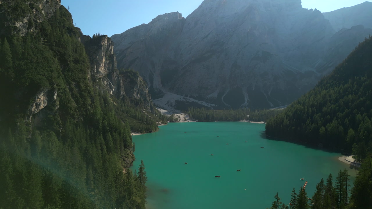 Full length of emerald green Lago di Braies, Italy. The lake is nestled between dense pine forests and massive dolomitic cliffs. Static aerial ascent. DJI Mini 3 Pro in 4K, Apple ProRes at 25fps.