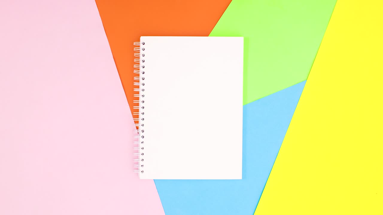 Open notebook and colored pencils appear around. Stop motion