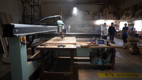 cnc woodworking machine in a busy workshop with workers