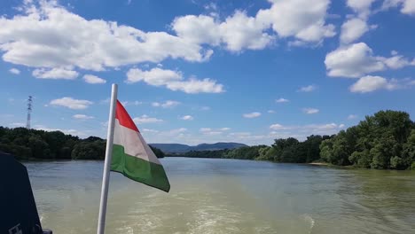 navegación a cámara lenta con un barco en un río con nubes esponjosas en un día soleado de verano bandera húngara