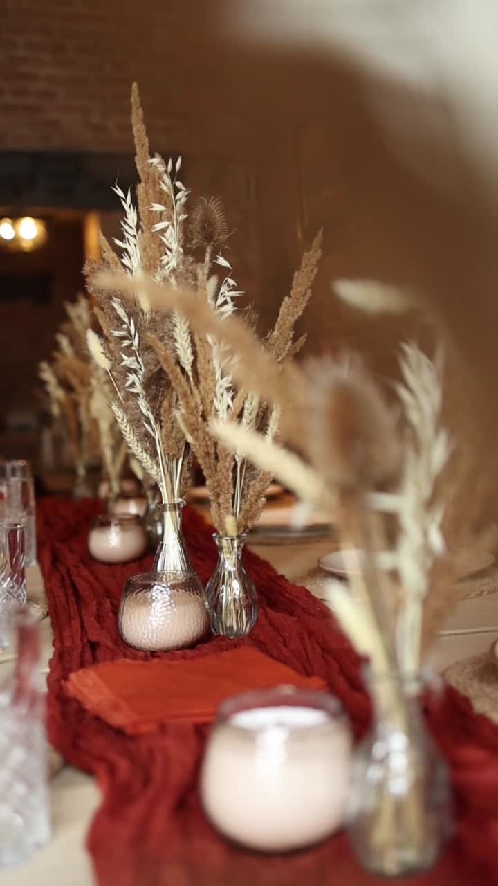Elegant borddekorasjon med tørkede blomster og stearinlys