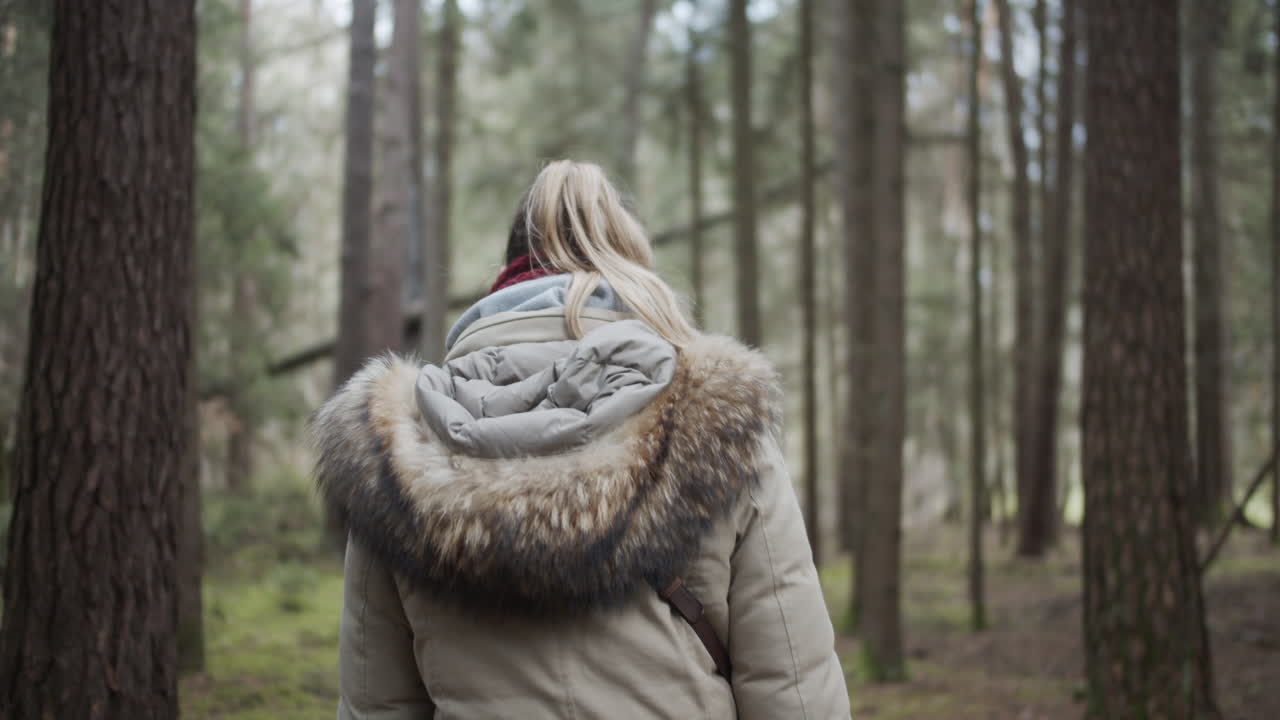SLOW MOTION: Young woman smiles and walks happy through forest