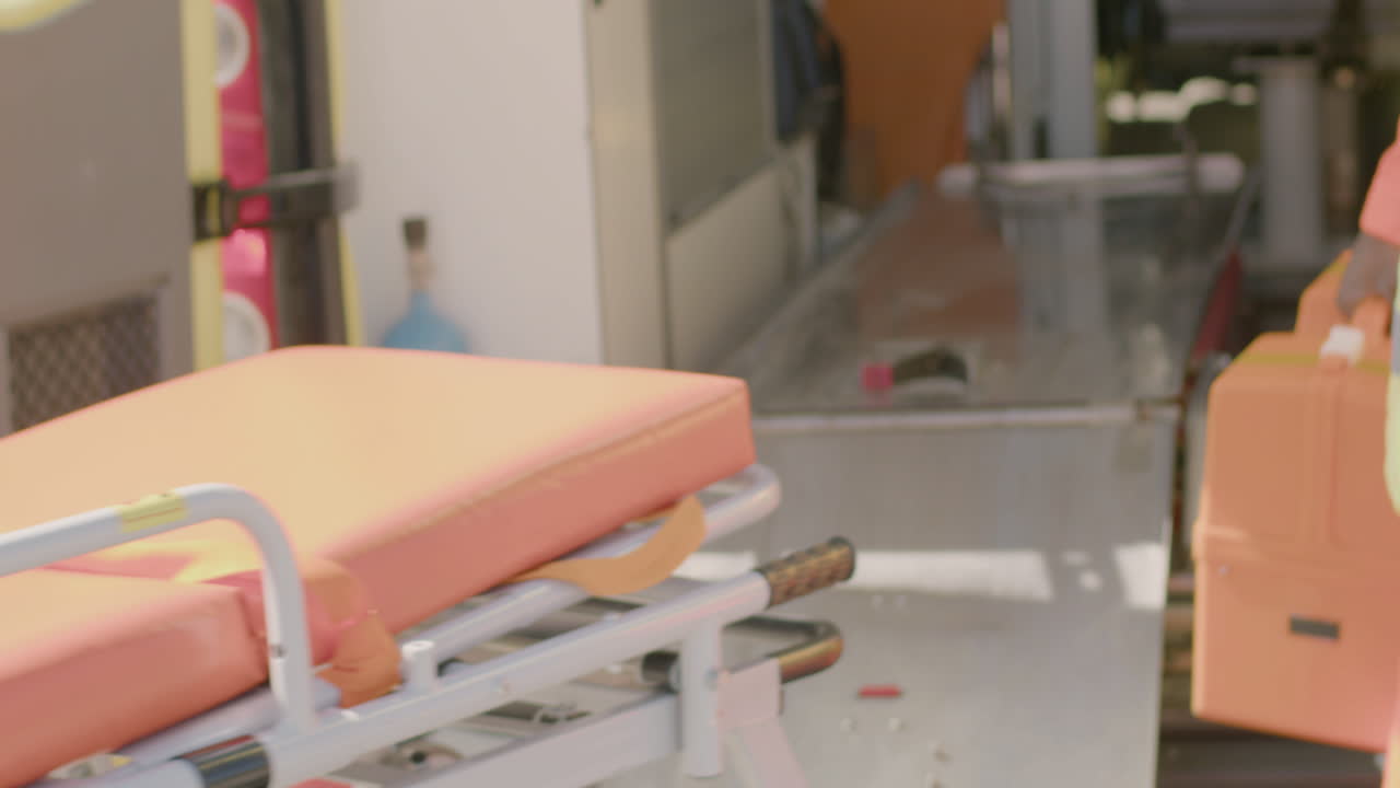 응급 상황에 참석하기 위해 구급차에서 들것을 가져가는 구급대원의 뒷모습