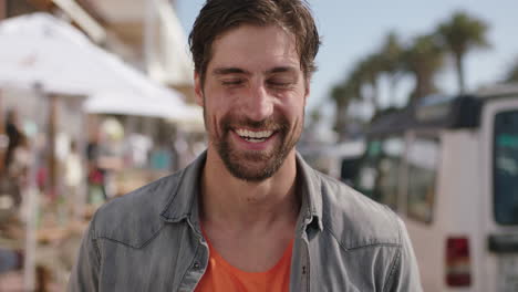 portrait of attractive man laughing enjoying sunny beachfront on vacation