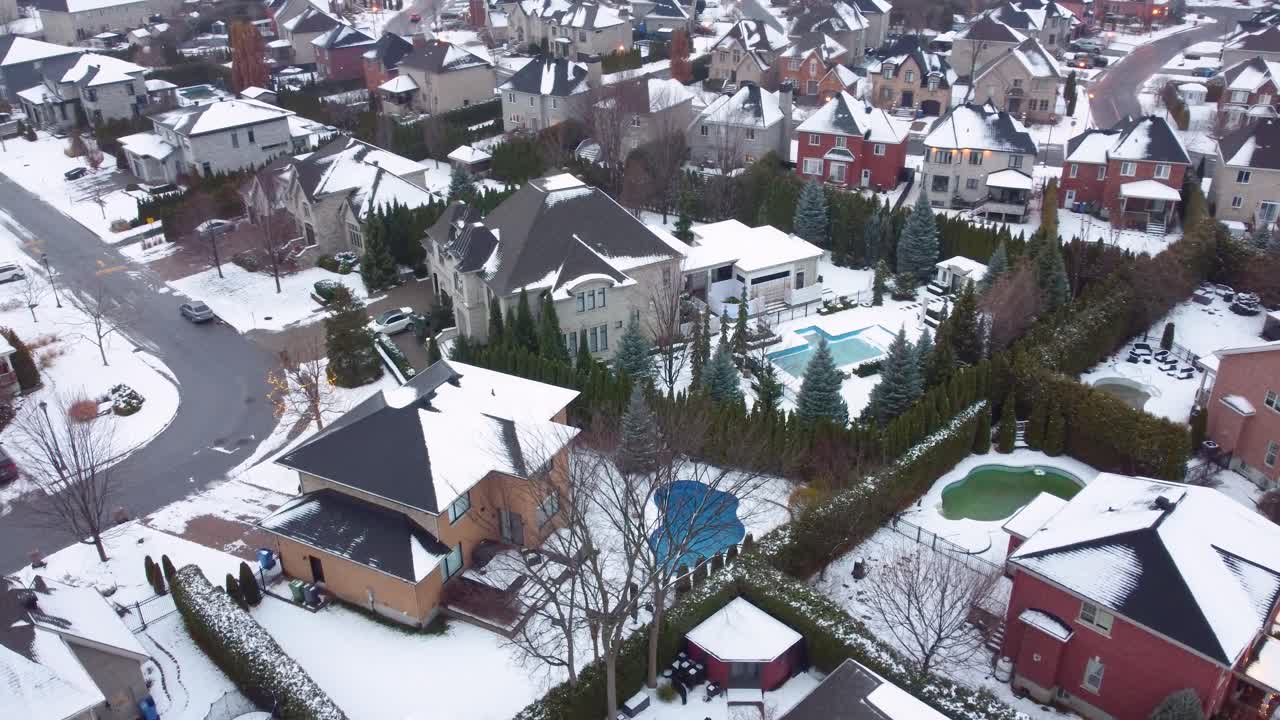 Snow covered houses in Brossard Canada during winter with swimming pools in the back yard. Mansions in suburban area