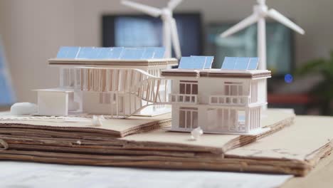 model of a small house with solar panel is on the table at the office