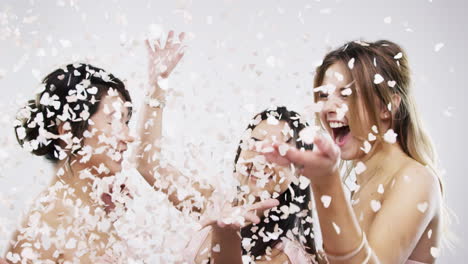 happy bridesmaids throwing confetti