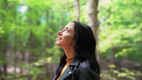 fast revolving gimbal shot circling young attractive woman who is in awe of the woodland forest - end with transition - concept: light, confidence, freedom, power, direction, worthy, path, outlook