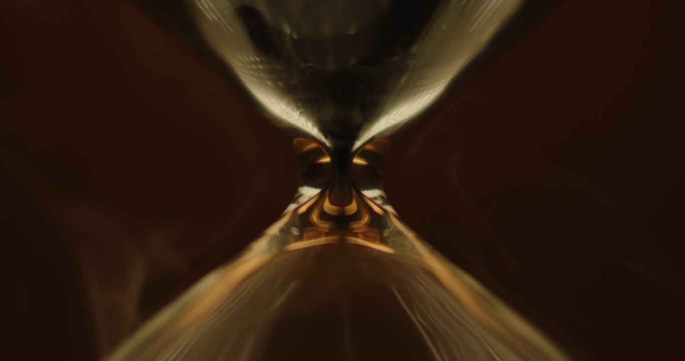 Hourglass on beautiful golden background