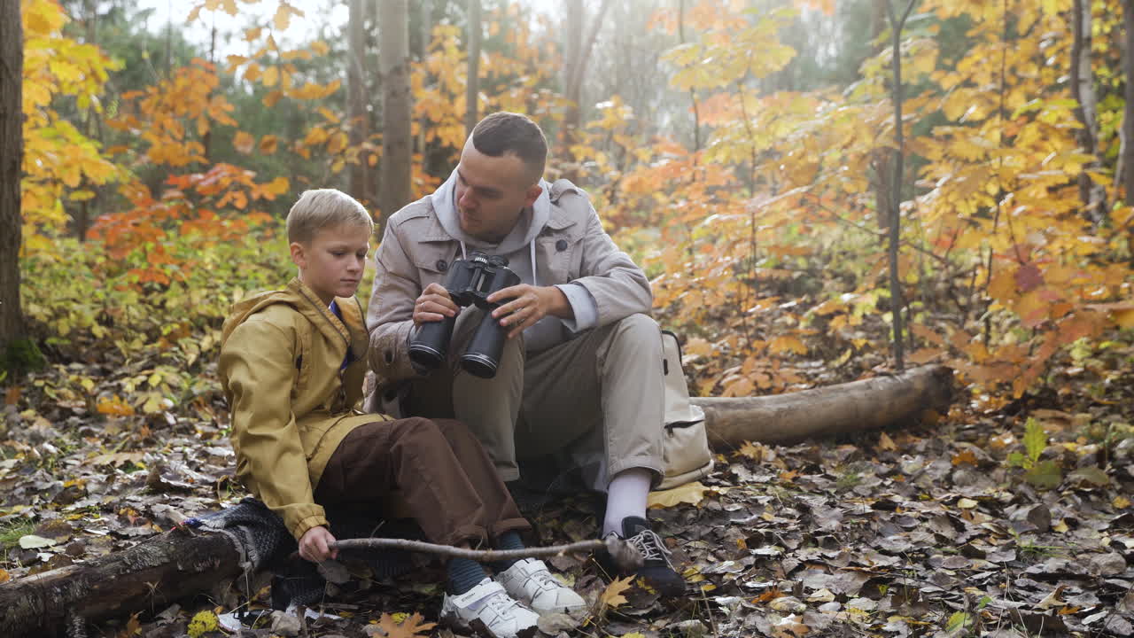 padre e hijo sentados en el bosque