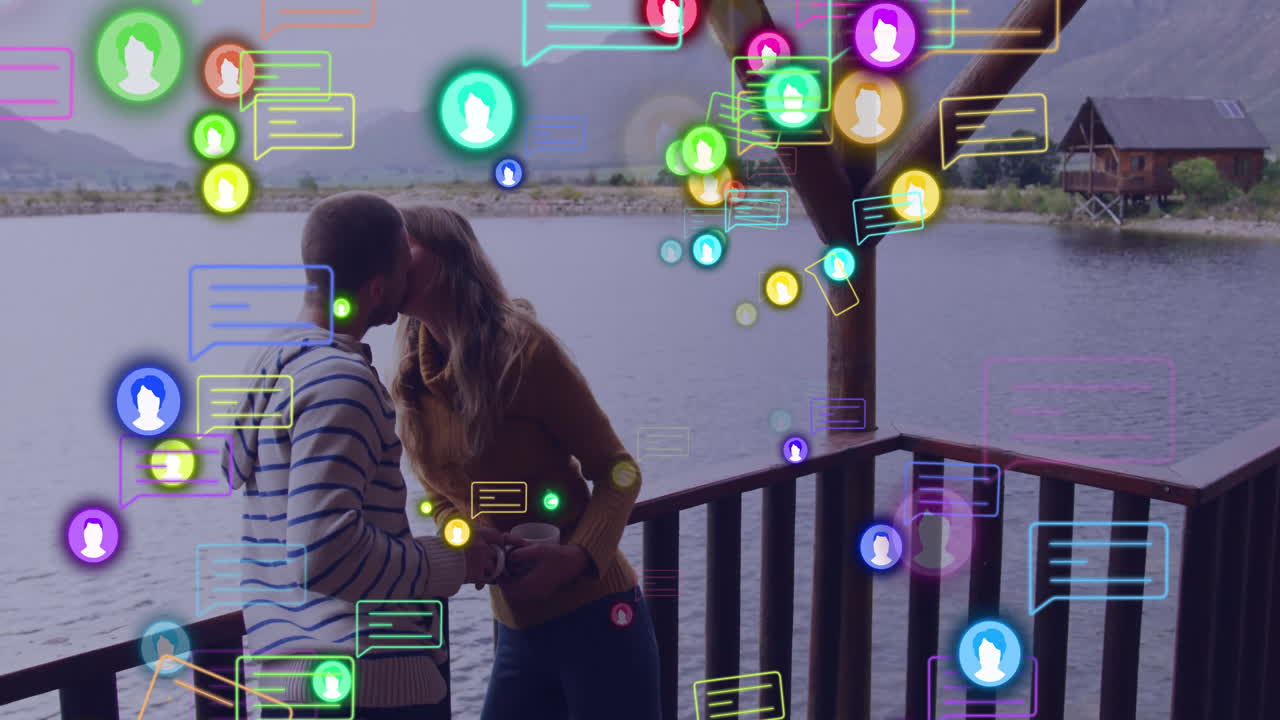 Embracing couple on lakeside deck with colorful animation of social media icons