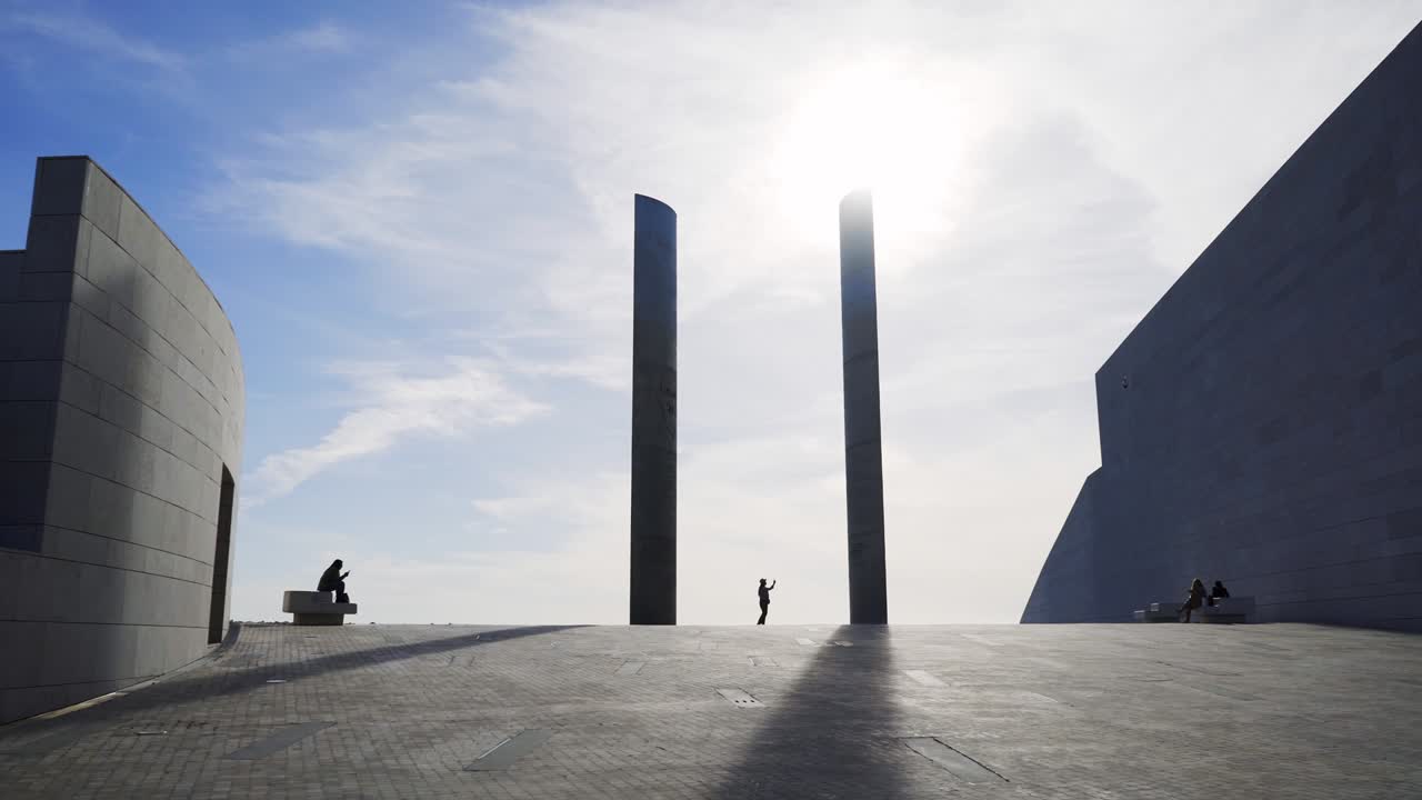 현대적인 기둥 근처에서 셀피를 찍는 실루의 여성