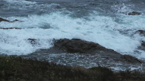 Waves-crashing-over-rock-at-Cape-Paterson-Bay-Beach,-Overcast-early-morning-blue-hour,-Australia-Victoria