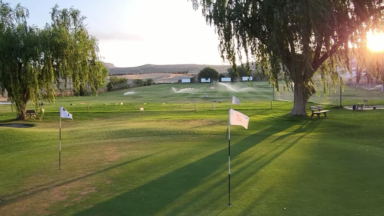 Golf course practice area at sunset. Range practice area golf club. Green, flags and golf holes. practice facility golf area. Granada. Spain