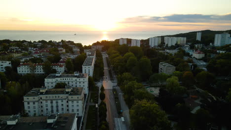 Epischer,-Erstaunlicher-Drohnenschuss-über-Gdynia,-Der-An-Einem-Frühen-Morgen-In-Eine-Leere,-Von-Bäumen-Gesäumte-Straße-Hinabsteigt