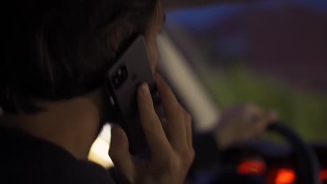 side view of a man talking by phone during driving at night city