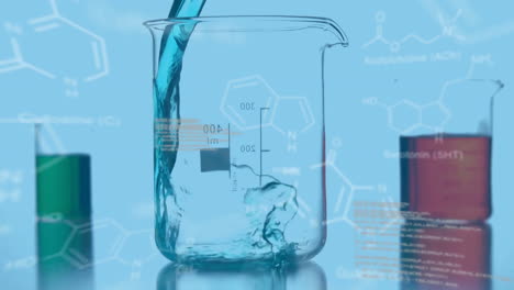 vasos de laboratorio con datos y fórmula estructural de compuestos químicos en primer plano