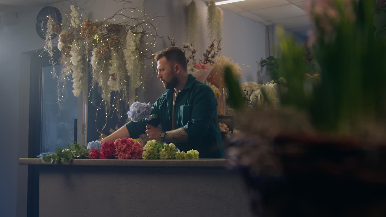 el florista agrega ramas a las hermosas flores