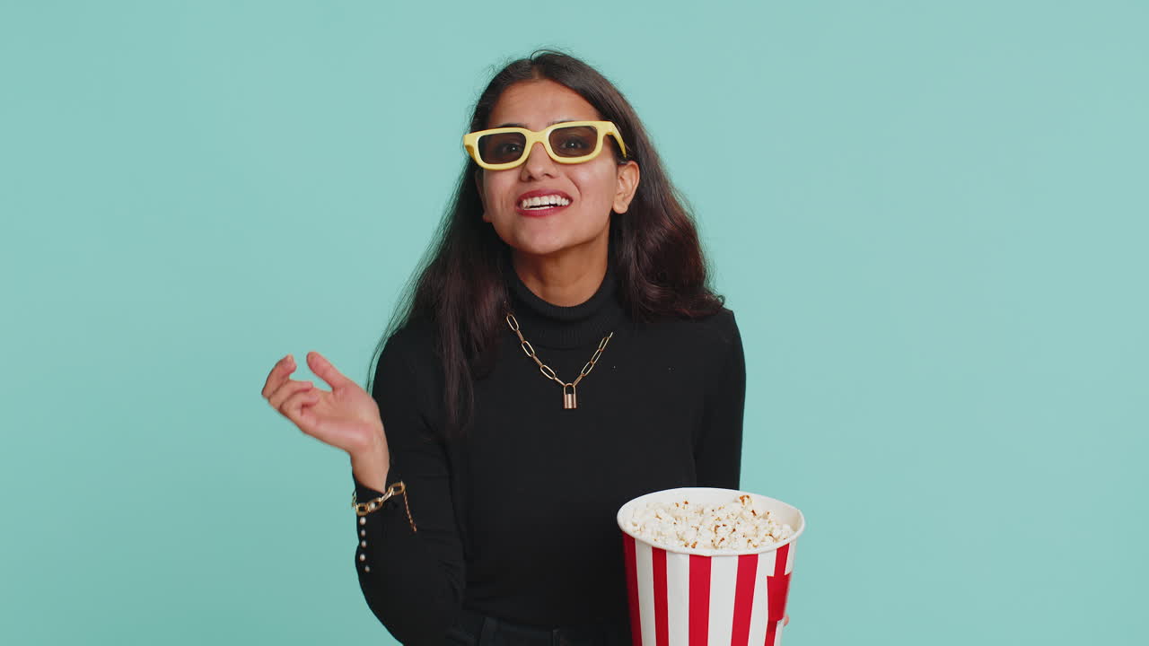 mujer india emocionada comiendo palomitas de maíz, viendo interesantes series de televisión, juegos deportivos, películas, películas en línea