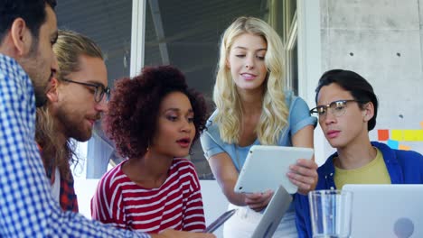 colleagues discussing over digital tablet 4k