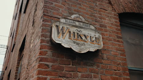a vintage wikyle whiskey sign on an old brick building