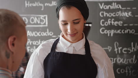 Mujer-Barista-Feliz-Sirviendo-Al-Cliente-Haciendo-Pagos-Usando-Un-Reloj-Inteligente-Comprando-Café-Gastando-Dinero-En-La-Cafetería