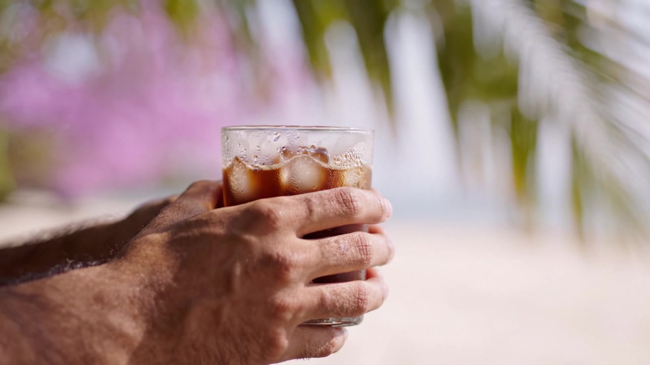 Una bevanda rinfrescante in un ambiente soleggiato, che cattura l'atmosfera vibrante e la gioia del relax con una bevanda fresca in mano immersi nella bellezza della natura.