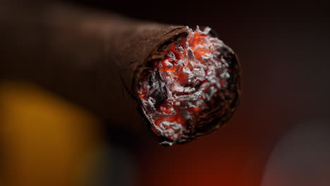 burning cuban cigar with tobacco ashing in macro, hand rolled premium quality