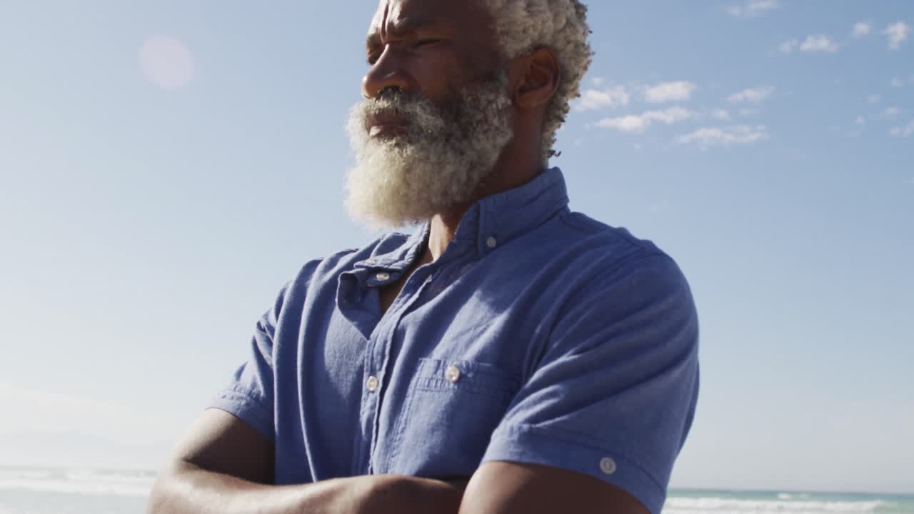 Homem afro-americano idoso olhando para longe em uma praia ensolarada
