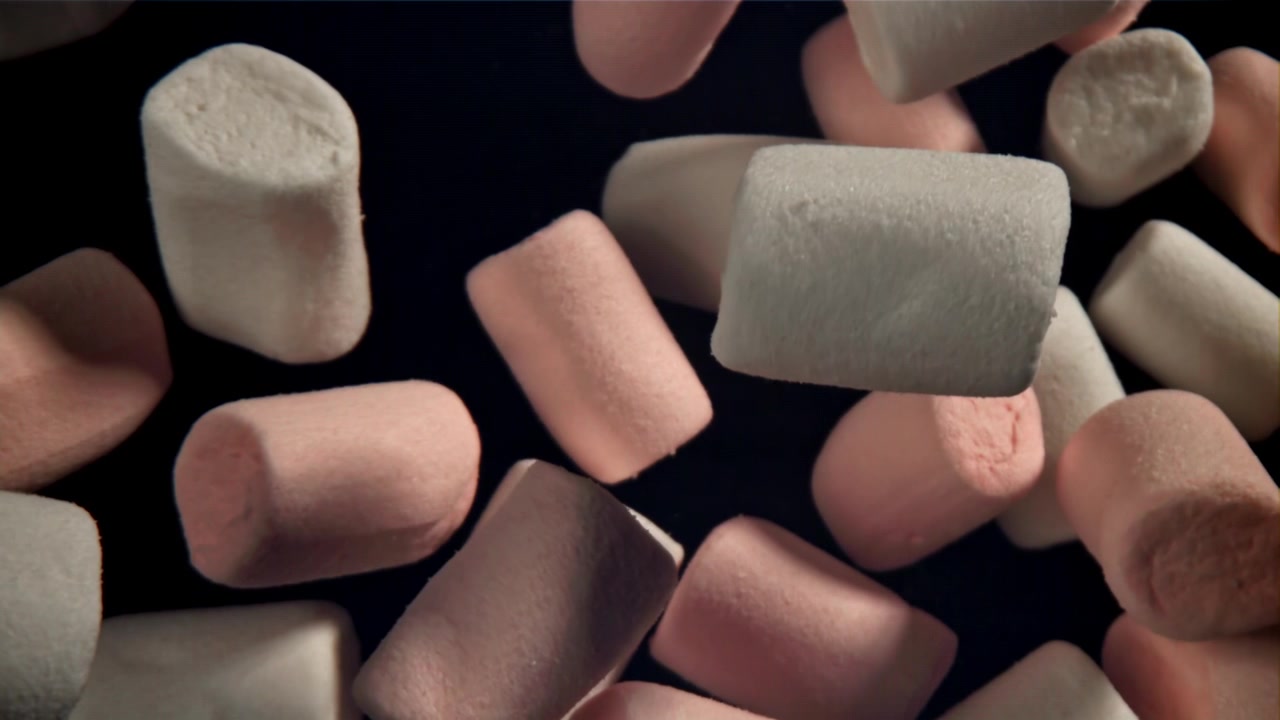 Marshmallow Rosa e Bianchi che Galleggiano su Sfondo Scuro